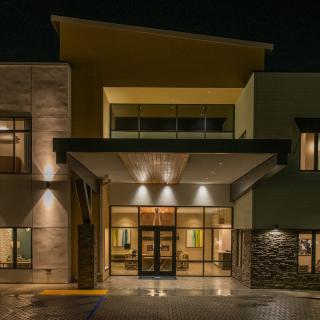 A modern building entrance illuminated at night.