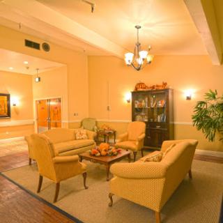 A cozy living room with soft yellow tones, comfortable seating, and a welcoming atmosphere.