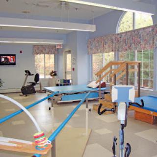 A spacious physical therapy room equipped with exercise machines and rehabilitation tools.