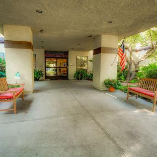 The entrance to a building with benches and an American flag.