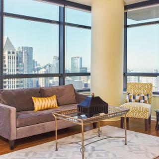 A modern living room with large glass windows offering a stunning city view.