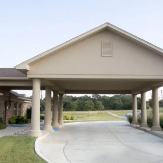A covered driveway entrance with large columns and a peaked roof.