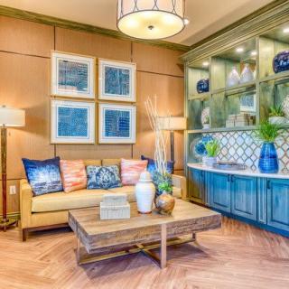 A modern living room with a cozy sofa and stylish decor, featuring artwork and elegant lighting.