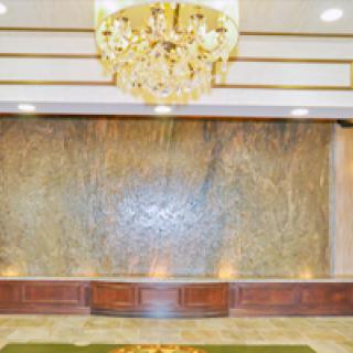 A luxurious hotel lobby featuring an elegant chandelier and a decorative waterfall.