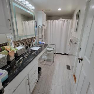 A stylish and modern bathroom featuring a sleek vanity, elegant lighting, and a clean shower area.