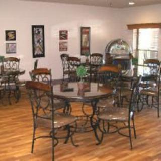 A cozy cafe interior with decorative tables and chairs on a wooden floor.