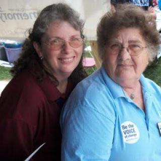 Two women smiling at an outdoor event.