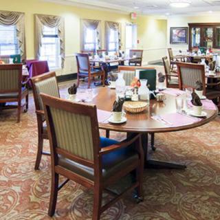 A well-furnished dining area with round tables and cushioned chairs, adorned with elegant decor.