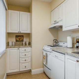 A compact kitchen with white cabinets and modern appliances.