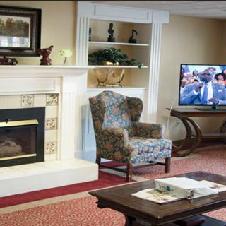 Cozy living room with a fireplace, armchair, and TV.
