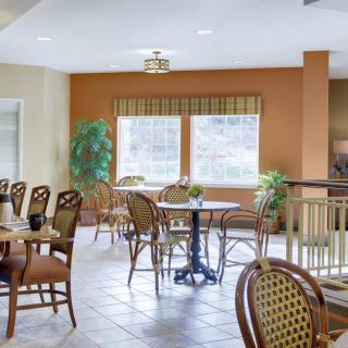 A cozy dining area with tables, chairs, and large windows providing natural light.