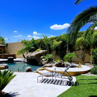A tranquil backyard oasis featuring a sparkling pool surrounded by lush greenery and comfortable lounging areas.