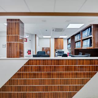 A modern office reception area featuring wooden design elements and a clean, organized workspace.