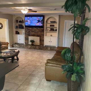 A cozy living room featuring a television, comfortable seating, and decorative elements.