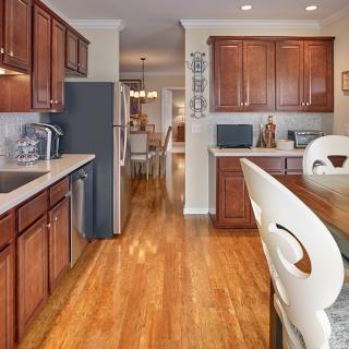 A modern kitchen with wooden cabinets and a hardwood floor.