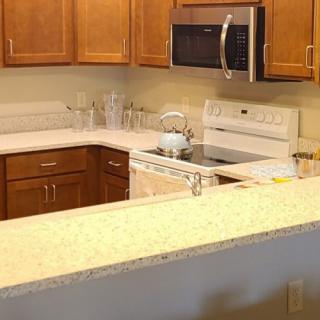 A modern kitchen with wooden cabinets and a range of appliances.