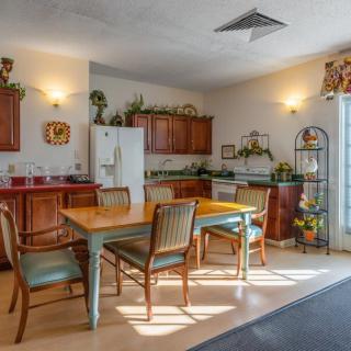 A cozy kitchen and dining area featuring wooden cabinets, a dining table with chairs, and decorative elements.