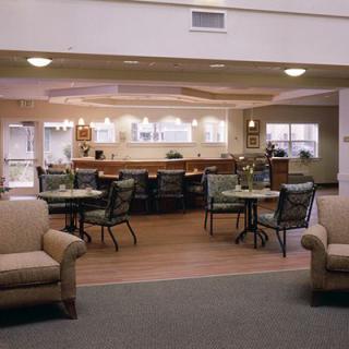 A spacious lobby with comfortable seating and tables, featuring a modern interior design.