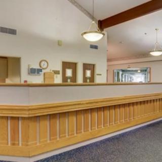 A spacious reception area with wooden paneling and ceiling lights.