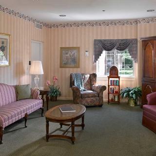 A cozy vintage-style living room with striped wallpaper and classic furniture.