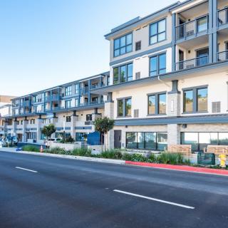 Modern apartment building with balconies and a clear blue sky.