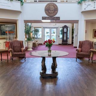 A welcoming lobby interior featuring a central table with flowers and comfortable seating.
