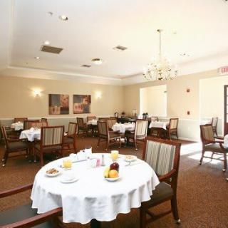 A cozy dining room with round tables and elegant table settings.