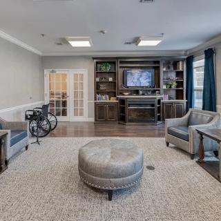 A modern living room with comfortable seating, a bookshelf, and a television.