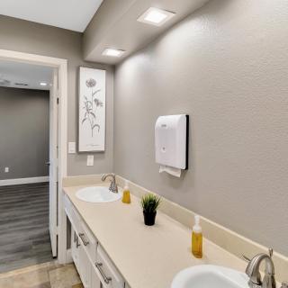 A modern bathroom interior featuring dual sinks, stylish lighting, and minimalist decor.