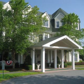 A welcoming hotel entrance with a canopy surrounded by greenery.