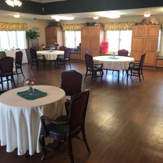 A spacious dining room with round tables and elegant chairs arranged neatly.