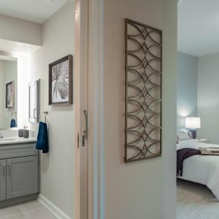 Modern apartment interior showing a bathroom and bedroom with stylish decor.