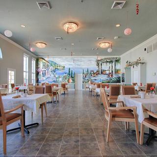 Spacious restaurant interior with neatly arranged tables and chairs.