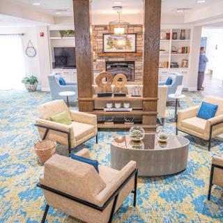A cozy and modern lobby featuring comfortable seating, vibrant carpeting, and a welcoming atmosphere.