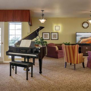 A cozy living room with a grand piano and comfortable seating.