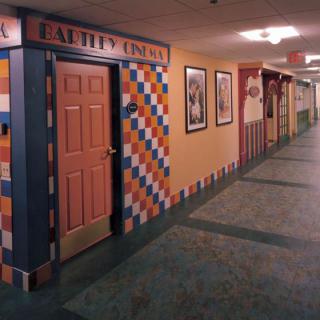 A vibrant hallway with patterned walls and framed pictures.