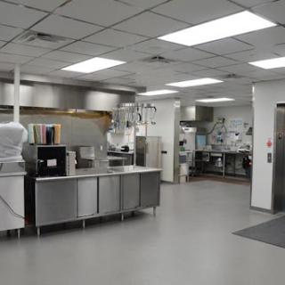 A spacious and well-equipped commercial kitchen featuring stainless steel appliances and a clean, organized layout.