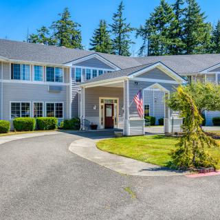 A large residential building with a well-maintained driveway and surrounding greenery.