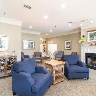A cozy living room with blue armchairs and a fireplace.