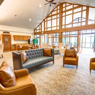 A spacious lobby area featuring modern furniture, large windows, and wooden beams.