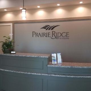 A modern reception area with a Prairie Ridge sign and contemporary lighting.