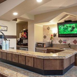 A modern restaurant interior featuring a bar counter with a television.