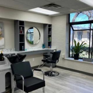A modern hair salon with stylish decor, featuring comfortable chairs and an inviting atmosphere.