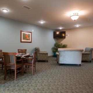 A cozy indoor room featuring a seating area with a sofa, chairs, and a table under soft lighting.