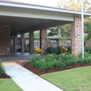 A brick building with a covered entrance and well-maintained landscaping.