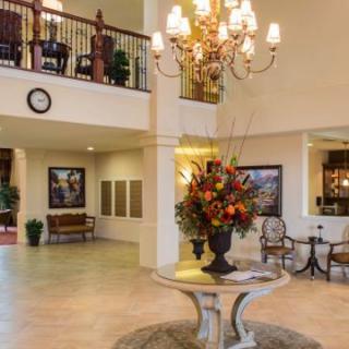 Luxurious lobby interior with a chandelier and flower arrangement.