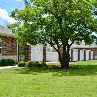 A suburban house with a large tree and well-maintained lawn.