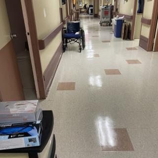 A hospital corridor with medical equipment and supplies along the sides.