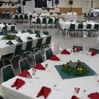A banquet hall set up for an event with decorated tables and chairs.
