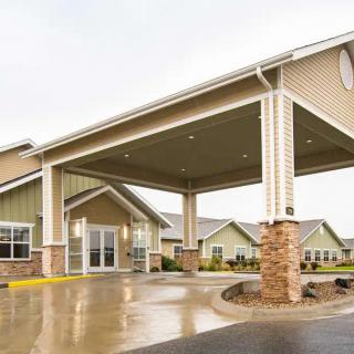 A modern building with a covered driveway entrance and stone accents.